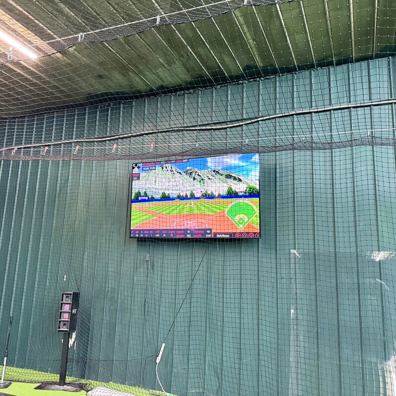 Indoor batting cage with mounted display